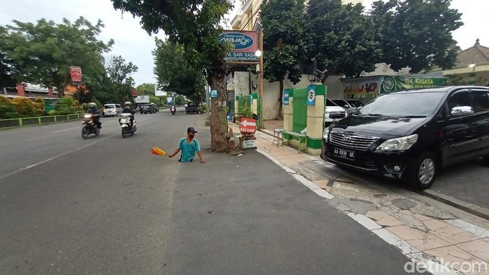 Meski memiliki keterbatasan fisik, Agus Slamet (35) tetap semangat bekerja menjadi juru parkir di Kudus, Selasa (2/3/2021).