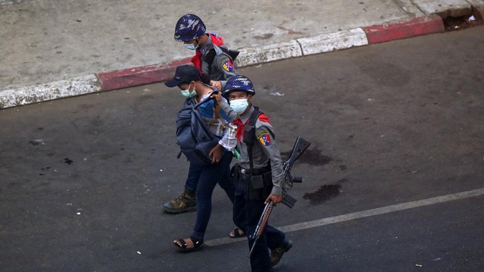 Police arrest Myanmar Now journalist Kay Zon Nwe in Yangon on February 27, 2021, as protesters were taking part in a demonstration against the military coup. (Photo by Ye Aung THU / AFP)