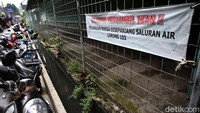 Imbauan berisi larangan mengambil ikan dari saluran air tampak menghiasi pagar di area sekitar saluran air itu.