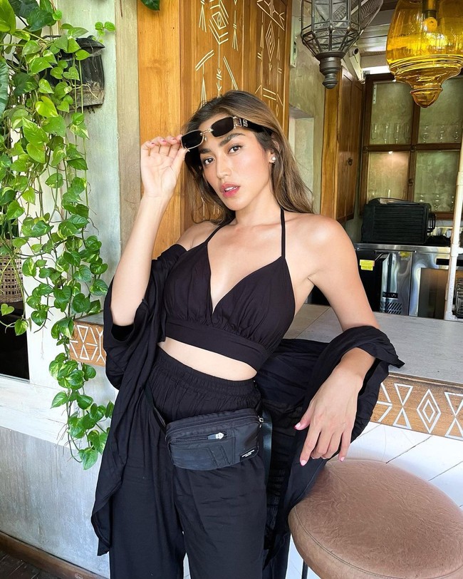 Terlepas dari suasana Bali yang tropis, Jessica Iskandar memilih look serba hitam. Padanan crop top, harem pants dan fanny pack membuat gayanya terlihat kekinian. (Foto: Instagram/@inijedar)