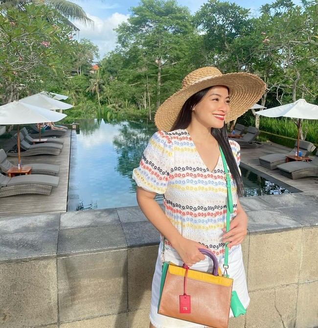 Titi Kamal menebar pesonanya dengan dress bermotif warna-warni yang matching dengan handbag-nya. (Foto: Instagram/@titi_kamall)