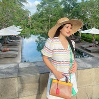 Titi Kamal menebar pesonanya dengan dress bermotif warna-warni yang matching dengan handbag-nya. (Foto: Instagram/@titi_kamall)