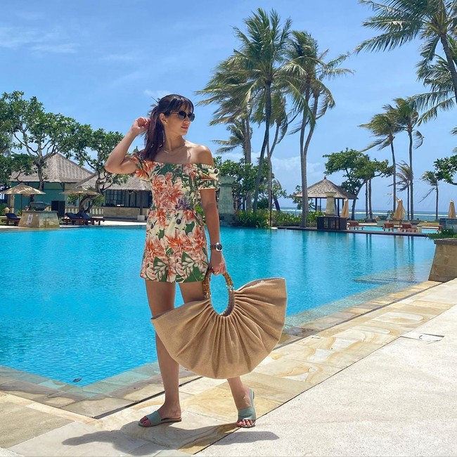 Bukan Nia Ramadhani namanya kalau tidak stylish. Di bali, busana floralnya dipadukan dengan statement bag yang unik. (Foto: Instagram/@ramadhaniabakrie)