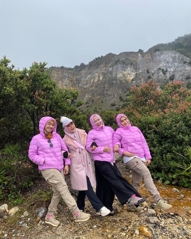 Tampil kompak, tiga sahabat April memakai puffer jacket warna fushia. Mereka asyik duduk sambil berpose saling bergandengan tangan. Foto: Dok. Instagram @apriljasmine85.