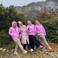 Tampil kompak, tiga sahabat April memakai puffer jacket warna fushia. Mereka asyik duduk sambil berpose saling bergandengan tangan. Foto: Dok. Instagram @apriljasmine85.