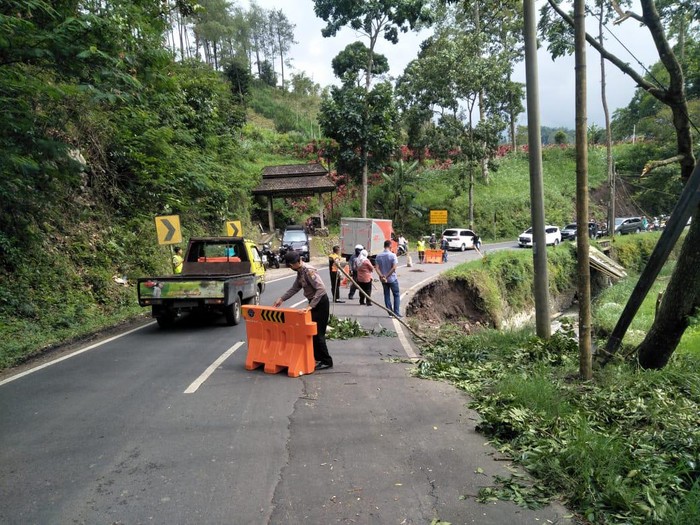 Bahu Jalan Brigjen Abdul Manan di Desa Ngroto, Kecamatan Pujon, Kabupaten Malang ambles. Bahu jalan tersebut tergerus air Sungai Konto yang mengalir di sisi timur jalan.