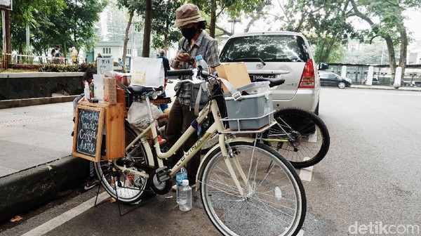 Angga Gilang Ramadhan menjual kopi keliling menggunakan sepeda di kawasan Lapangan GOR Saparua, Kota Bandung. Angga Gilang Ramadhan menjual kopi keliling menggunakan sepeda di kawasan Lapangan GOR Saparua, Kota Bandung.