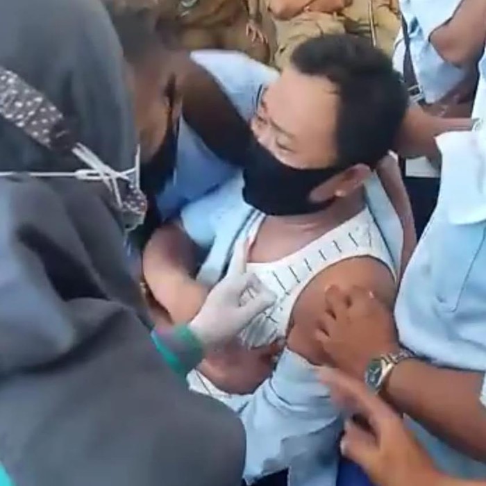Beredar video seorang pria ketakutan saat akan disuntik vaksin COVID-19. Ia tampak tidak bisa diam karena takut hingga ditemani rekan-rekannya.