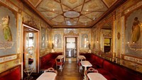 Caffe Florian terkenal dengan teras luar ruangan yang luas dan interior bergaya abad ke 18, dihiasi dengan beludru merah dan cermin berlapis emas. (Caffe Florian)