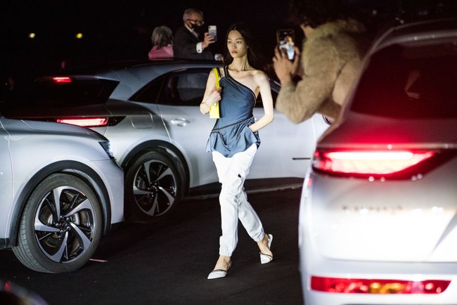 Tampak para tamu menonton fashion show dari dalam mobil. Ada pula yang mencoba mengambil foto untuk mengabadikan suasana pagelaran busana yang terbilang unik ini. Foto: Getty Images/Pascal Le Segretain