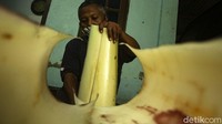 Seorang warga memilah batang pohon pisang yang nantinya akan dijadikan keripik.