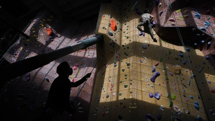Melihat Olahraga Panjat Dinding di AS Audrey Grochowski, left, and Sam Masters wear protective face masks while working out at Planet Granite climbing gym during the coronavirus pandemic in San Francisco, Thursday, March 4, 2021. The gym opened today to allow ten percent capacity. (AP Photo/Jeff Chiu)