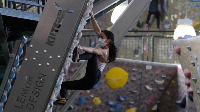 Audrey Grochowski, left, and Sam Masters wear protective face masks while working out at Planet Granite climbing gym during the coronavirus pandemic in San Francisco, Thursday, March 4, 2021. The gym opened today to allow ten percent capacity. (AP Photo/Jeff Chiu)