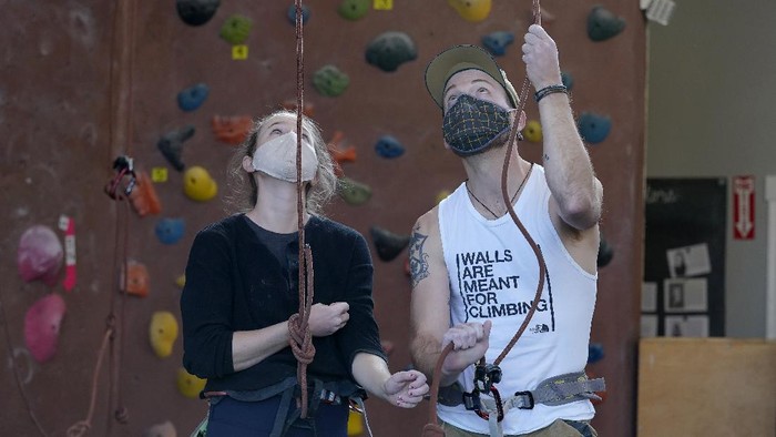 Melihat Olahraga Panjat Dinding di AS Audrey Grochowski, left, and Sam Masters wear protective face masks while working out at Planet Granite climbing gym during the coronavirus pandemic in San Francisco, Thursday, March 4, 2021. The gym opened today to allow ten percent capacity. (AP Photo/Jeff Chiu)