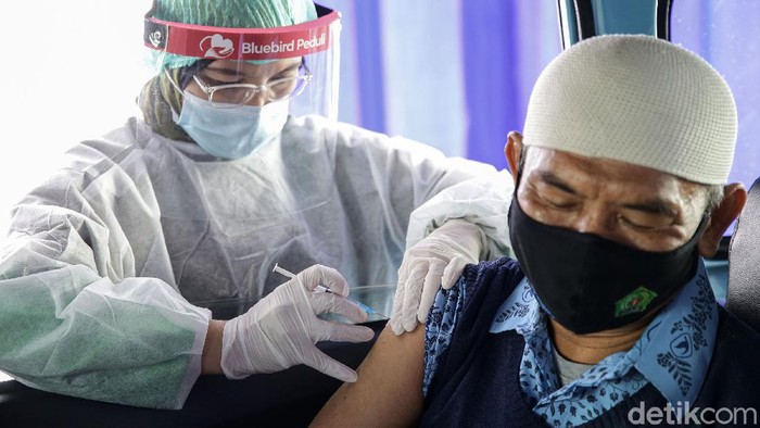 Petugas vaksinator menyuntikan vaksin kepada para pengemudi taksi dan lansia saat dilakukannya pelaksanaan program vaksinasi pengemudi taksi Bluebird dan lansia (orang tua pengemudi) di Pool Bluebird Jalan Mayjen Sutoyo, Cawang, Jakarta Timur, Jumat (5/3/2021).