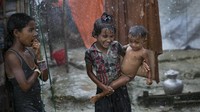 Anak-anak Rohingya bermain di bawah hujan di pengungsian Coxs Bazar, Bangladesh. Getty Images/Allison Joyce