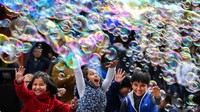Seorang artis jalanan di Royal Mile menghibur anak-anak dengan gelembung sabun di Edinburgh, Skotlandia. Getty Images/Jeff J Mitchell