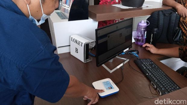 Tamu menempelkan e-KTP di mesin yang disediakan untuk mengisi buku tamu di Unit Layanan di Kemendagri