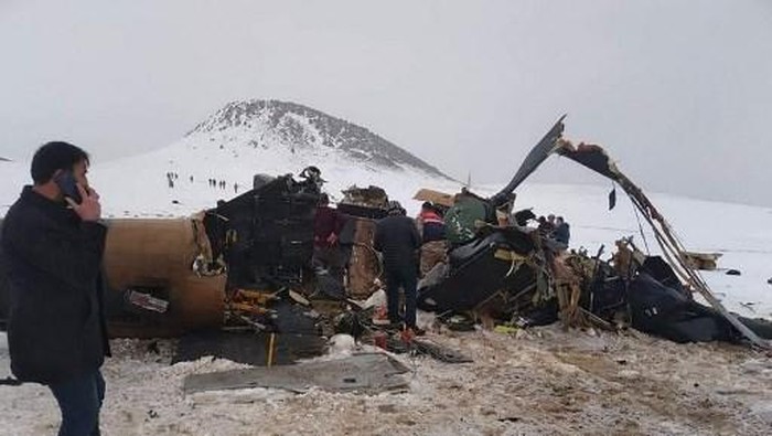 Rescue workers, soldiers and civilians walk around the wreckage of a military helicopter that crashed on March 4, 2021, near the Turkish eastern city of Bitlis. - Nine Turkish soldiers were killed and four wounded on March 4, when their military helicopter crashed in the southeast of the country, the defence ministry said. The helicopter crashed in the town of Tatvan, in the predominantly Kurdish-populated Bitlis province. The ministry said the accident involved a Cougar helicopter but provided no details about the model. (Photo by - / IHLAS NEWS AGENCY / AFP) / Turkey OUT