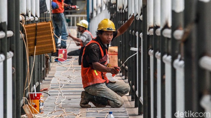 Para pekerja menyelesaikan proses konstruksi jembatan pejalan kaki di Halte Busway Karet Kuningan, Jl Rasuna Said, Jakarta, Sabtu (6/3/2021).