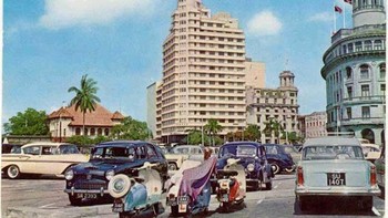 Kota Singapura mulai menggeliat dengan jalanan yang rapi dan kendaraan masa itu. Foto: Vintag