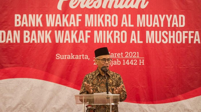 Ketua Dewan Komisioner Otoritas Jasa Keuangan (OJK) Wimboh Santoso (kiri) didampingi Wali Kota Solo Gibran Rakabuming Raka (kanan) dan Kepala OJK Solo Eko Yunianto (kedua kanan) menyerahkan bantuan kepada perwakilan Pondok Pesantren Al Muayyad pada acara Peresmian Bank Wakaf Mikro (BWM) Al Muayyad dan Al Mushoffa di Kantor OJK, Solo, Jawa Tengah, Minggu (7/3/2021). OJK saat ini telah mendirikan 60 BWM dengan diresmikannya BWM di Pondok Pesantren Al Muayyad dan Ponpes Al Qur'aniyy Azzayadiy, dengan total penerima manfaat sekitar 41.436 nasabah dan total pembiayaan mencapai Rp60,6 miliar. ANTARA FOTO/Mohammad Ayudha/rwa.