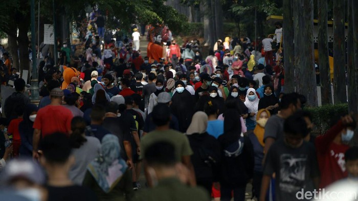 Potret Warga Berkerumun di Tengah Tingginya Kasus Corona Warga tampak berkerumun saat berolahraga di kawasan Kanal Banjir Timur, Jakarta Timur, Minggu (7/3). Padahal kasus positif COVID-19 di DKI masih tinggi.