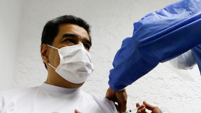 Handout photo released by Miraflores palace press office showing Venezuelas President Nicolas Maduro (L) receiving the first dose of the Sputnik V vaccine developed by Russia in Caracas, on March 6, 2021. (Photo by Jhonander Gamarra / AFP)