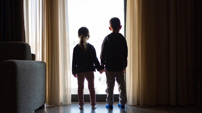1214588868 Boy and girl from back, looking trough the window.