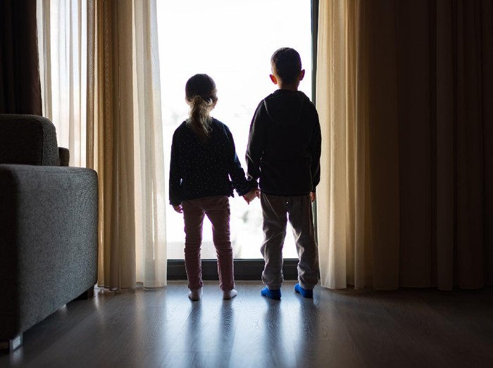 1214588868 Boy and girl from back, looking trough the window.