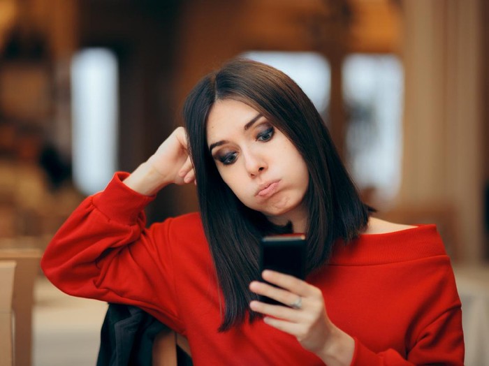 Girlfriend checking her phone while her boyfriend is running late