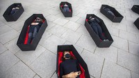Sejumlah Wanita tidur di dalam peti mati saat melakukan aksi jelang peringatan Hari Perempuan Sedunia atau International Womens Day di kawasan Tel Aviv, Israel, pada Minggu (7/3/2021) waktu setempat. AP Photo/Ariel Schalit.