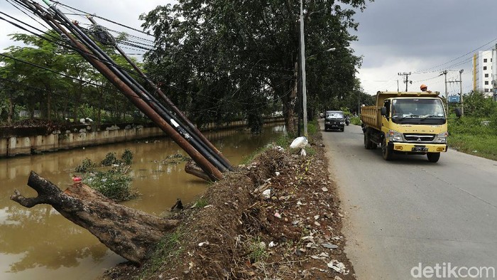 Sejumlah tiang kabel di Jalan Pangeran Jayakarta, Medan Satria, Kota Bekasi, miring yang nyaris ambruk ke sungai. Begini penampakannya.