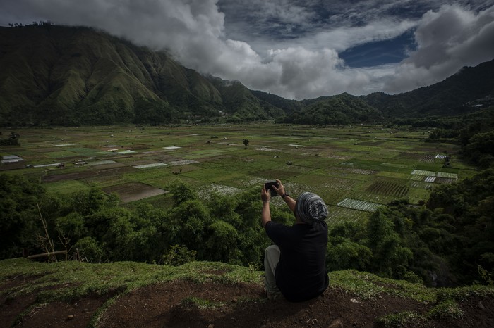 Wisatawan memotret dengan gawai di Bukit Selong, Sembalun Lawang, Sembalun, Lombok Timur, Nusa Tenggara Barat, Jumat (5/4/2020). Kawasan Sembalun yang berada di bawah kaki Gunung Rinjani itu menjadi salah satu destinasi wisata favorit di Nusa Tenggara Barat. ANTARA FOTO/Aprillio Akbar/rwa.