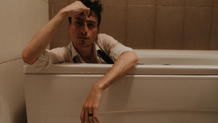 Ilustrasi pria sedih Young depressed male having anxiety alone himself in the bathroom. Young teenager male having breakdown alone.