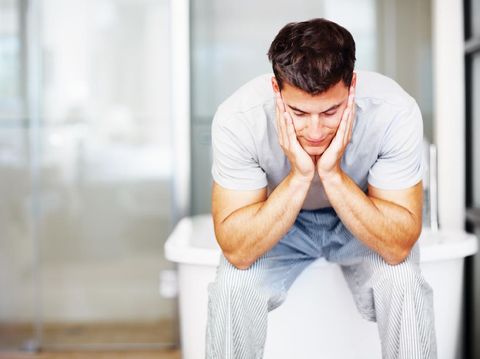 Young depressed male having anxiety alone himself in the bathroom. Young teenager male having breakdown alone.