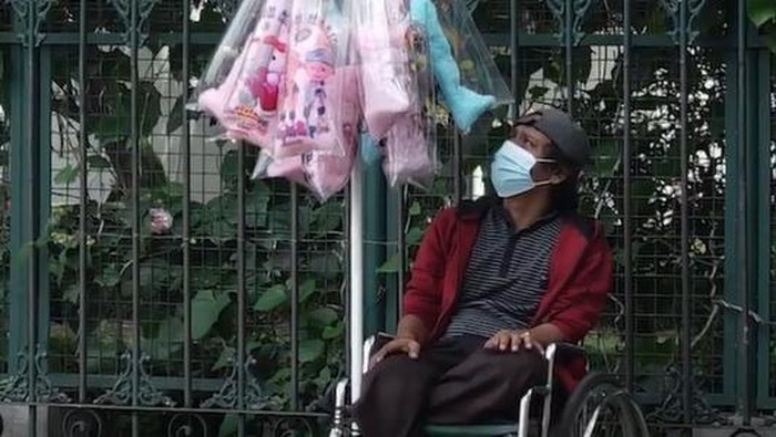 Pria penyandang disabilitas berjualan arum manis keliling Yogyakarta memakai kursi roda.