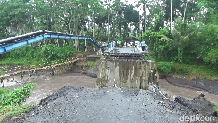 Sebuah jembatan penghubung antarkecamatan putus diterjang banjir lahar Gunung Semeru. Kini warga membuat jembatan darurat.
