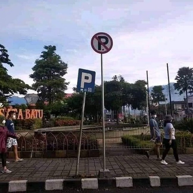 Nah bingung nggak nih kalau nemuin tanda pemberitahuan kayak gini? Yang satu bilang dilarang parkir, satunya lagi boleh parkir. Jadi yang mana yang benar dong? Foto: Instagram/@humorsantuy