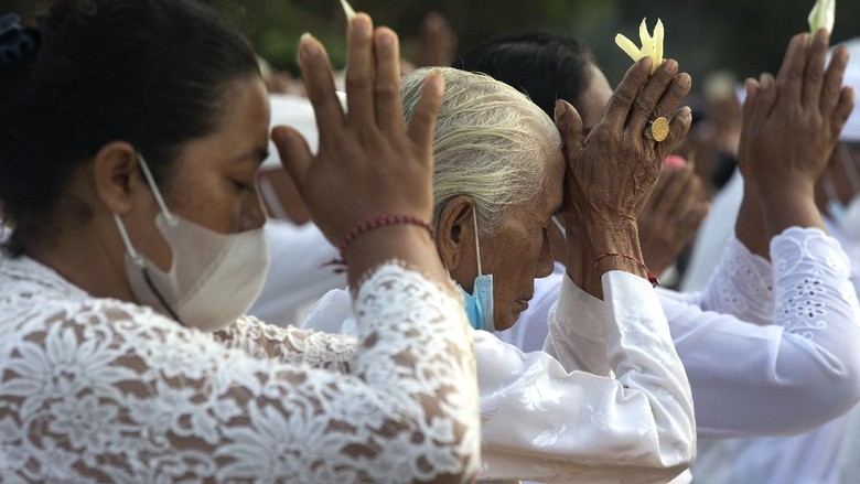 Jelang Nyepi, Ritual Melasti Mulai Digelar Balinese dip their feet in the sea during the ritual of Melasti in Bali, Indonesia, Thursday, March 11, 2021. The ritual, which is performed ahead of the Balinese Hindus Day of Silence, is held to purify the universe from bad influences, bad deeds and bad thoughts. (AP Photo/Firdia Lisnawati)