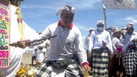 Seorang umat Hindu dalam keadaan tidak sadar menusukkan keris ke tubuhnya selama Upacara Melasti di Pantai Kuta, Bali, Kamis (11/3/2021). AP Photo/Firdia Lisnawati  