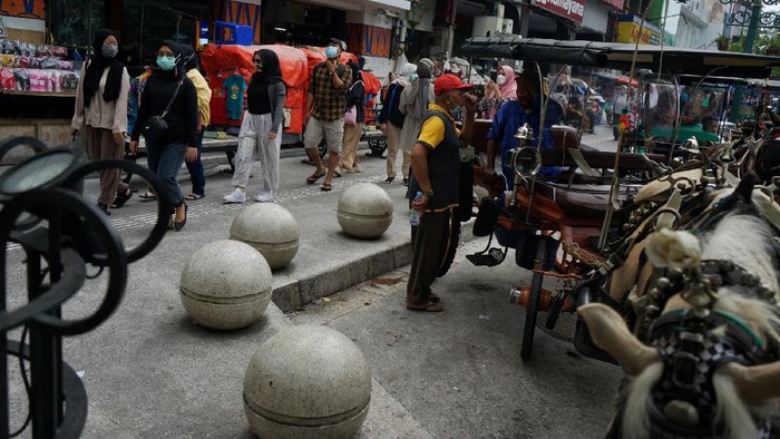 Pengunjung memadati kawasan wisata Malioboro, Yogyakarta, Kamis (11/3/2021). Libur Isra Miraj 2021 kawasan Malioboro yang merupakan destinasi wisata andalan di Yogyakarta padat pengunjung. ANTARA FOTO/Andreas Fitri Atmoko/rwa.