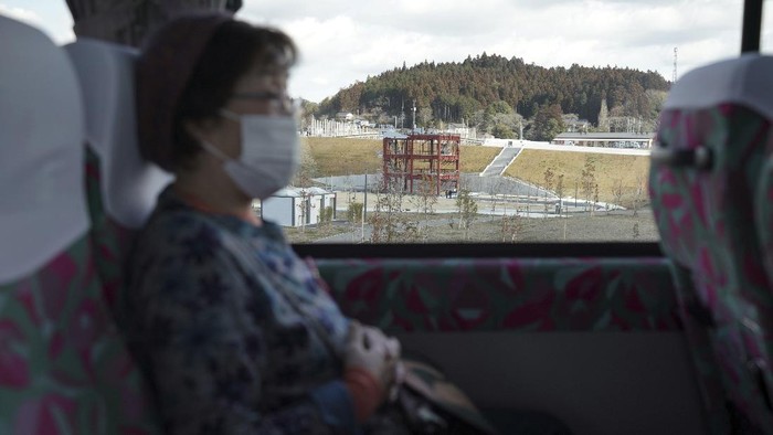 Menenang Satu Dekade, Ada Wisata Keliling Lokasi Tsunami Jepang Fumio Ito, head of public relations at Minami Sanriku Hotel Kanyo, tells his experience of 2011 tsunami disaster in the area to participants inside a bus during the