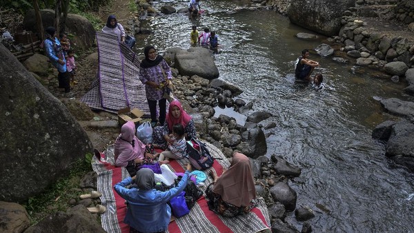 Pengunjung bermain di Sungai Cireong, Desa Sukaresik, Kecamatan Sindangkasih, Kabupaten Ciamis, Jawa Barat, Kamis (11/3/2021). ANTARA FOTO/Adeng Bustomi  