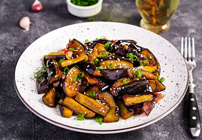 Hot spicy stew eggplant in Korean style with green onion. Aubergine saute. Vegan food.