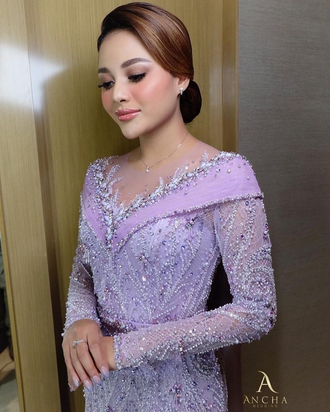 Aurel Hermansyah tampak cantik mengenakan balutan kebaya potongan hampir off shoulder yang dipenuhi dengan payet dan manik-manik. Kebayanya itu dipadukan dengan kain songket berwarna senada. Untuk mempercantik tampilannya, Aurel memilih makeup natural. Foto: Instagram/@anchawedding_