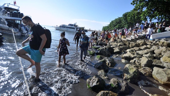 PENYEBERANGAN KAPAL CEPAT JELANG NYEPI Sejumlah penumpang antre menaiki kapal cepat di kawasan Sanur, Denpasar, Bali, Sabtu (13/3/2021). Penyeberangan kapal cepat yang menghubungkan Sanur dengan sejumlah tujuan seperti Pulau Nusa Penida dan Nusa Lembongan tersebut dipadati oleh warga dan wisatawan menjelang penutupan operasional penyeberangan saat Hari Raya Nyepi tahun Saka 1943. ANTARA FOTO/Fikri Yusuf/foc.
