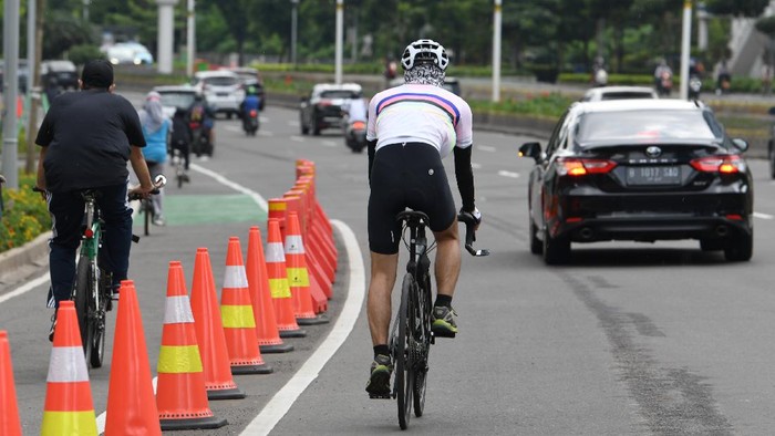 Pesepeda melintas di luar jalur sepeda di Jalan Jenderal Sudirman di Jakarta, Minggu (14/3/2021). Menurut Dirlantas Polda Metro Jaya Kombes Sambodo Purnomo Yogo pihaknya akan memberikan sanksi berupa denda sebesar Rp100.000 bagi pelanggar lalu lintas khusus kendaraan tidak bermotor dan ancaman sanksi lain berupa kurungan paling lama 15 hari kepada pesepeda yang melanggar jalur sepeda di wilayah DKI Jakarta. ANTARA FOTO/M Risyal Hidayat/aww.