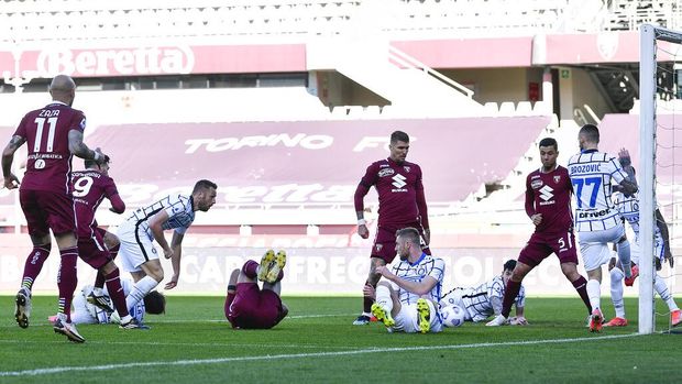 Torino's Antonio Sanabria, left, partially covered, scores his side's first goal during the Italian Serie A soccer match between Torino and Inter Milan at the Olimpico Grande Torino stadium in Turin, Italy, Sunday, March 14, 2021.  (Fabio Ferrari/LaPresse via AP)