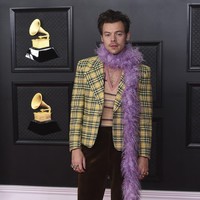 Harry Styles menunjukkan gaya khasnya yang eksentrik dengan setelan jas bernuansa 60-an keluaran Gucci. Syal bulu menjadi aksen pelengkap yang membuat penampilannya makin nyentrik. Foto: AP/Jordan Strauss